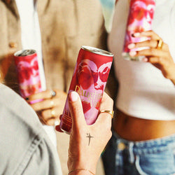 Three people holding Daughters of the Vine cans